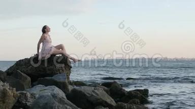夏日时尚时髦<strong>女郎</strong>穿着漂亮的裙子坐在<strong>沙滩</strong>上的石头上